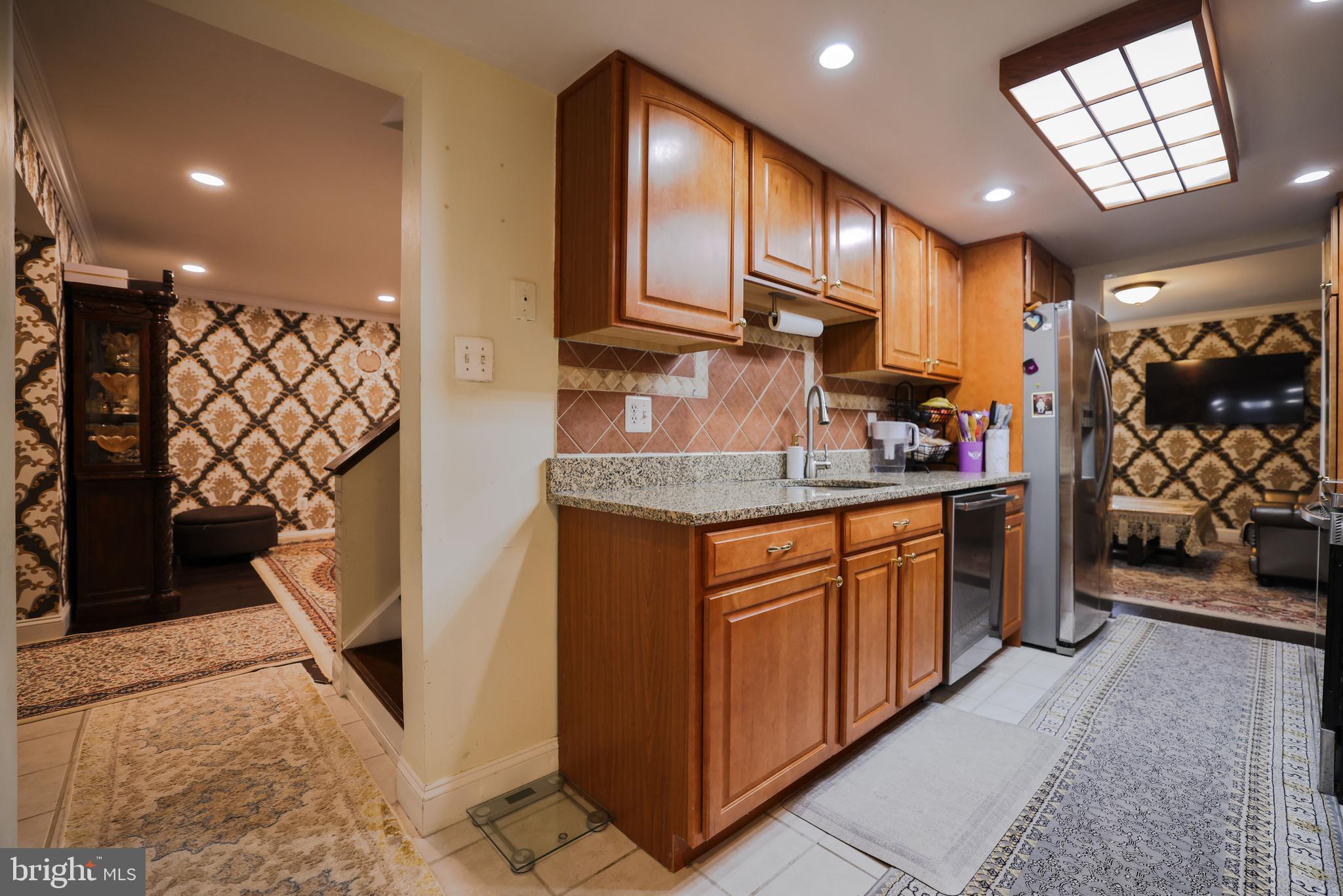 103 Garrison Court Langhorne, PA 19047 - Photo 13 of 46 a kitchen with stainless steel appliances granite countertop a refrigerator a sink and wooden cabinets