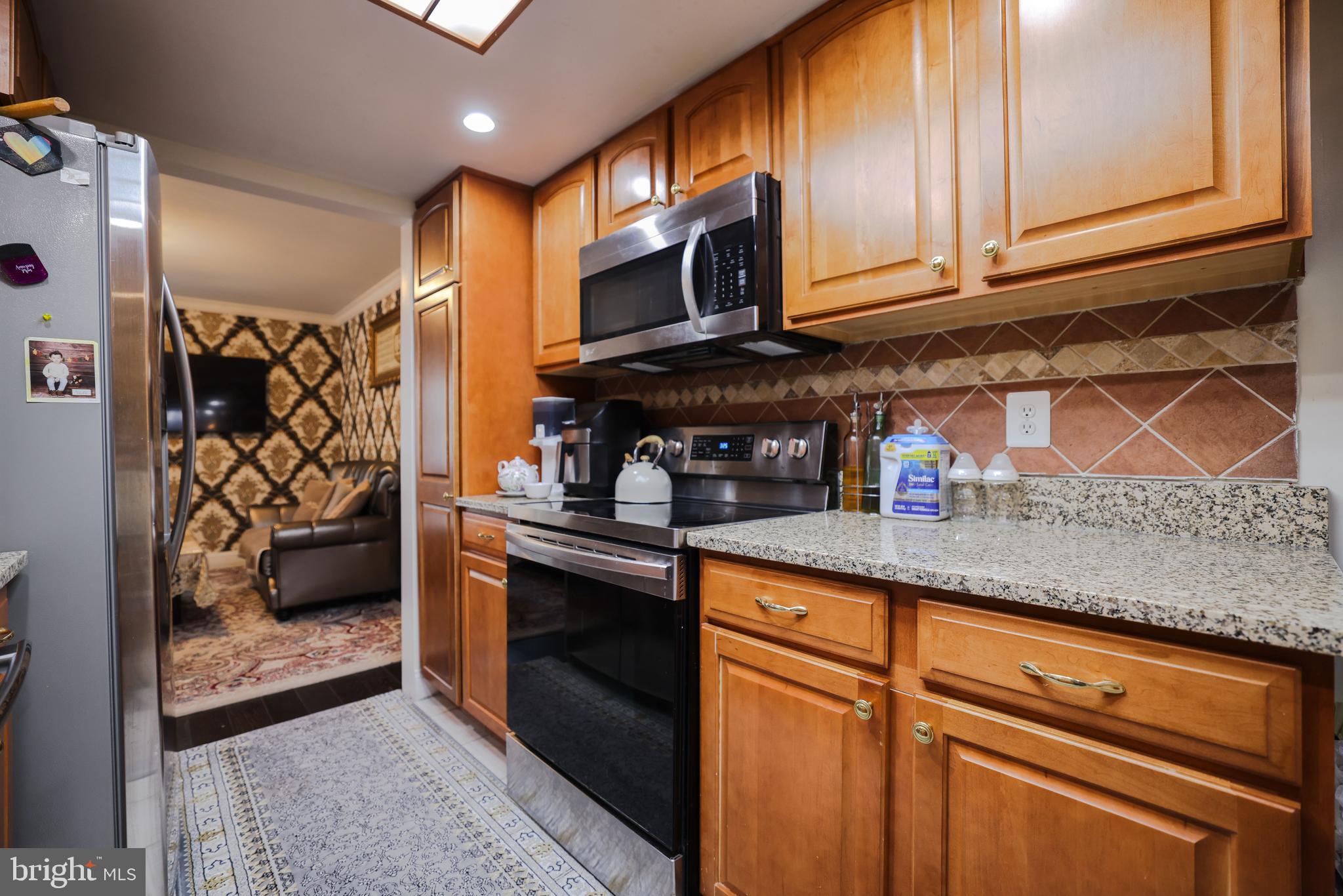 103 Garrison Court Langhorne, PA 19047 - Photo 10 of 46 a kitchen with stainless steel appliances granite countertop a refrigerator and a stove top oven