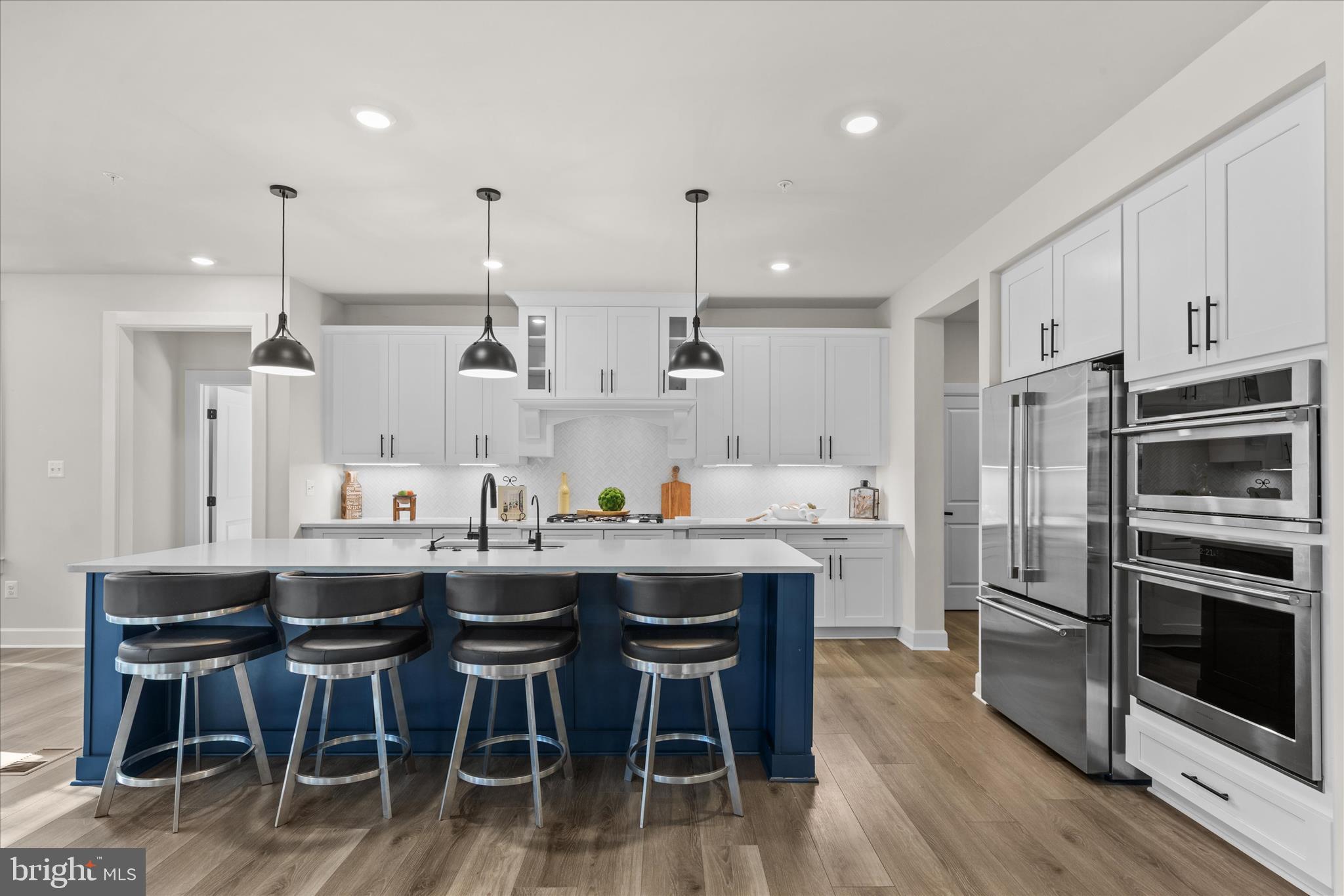 12377 Hidden Bay Drive Berlin, MD 21811 - Photo 12 of 71 a kitchen with stainless steel appliances kitchen island granite countertop a table chairs and wooden cabinets
