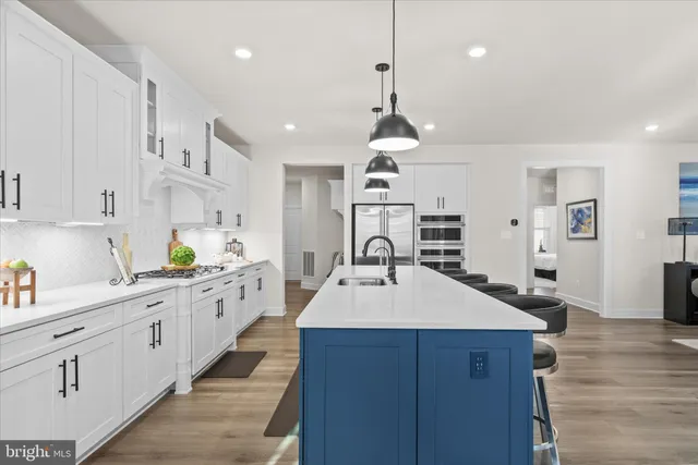 a dining room with wooden floor a chandelier a glass table and chairs