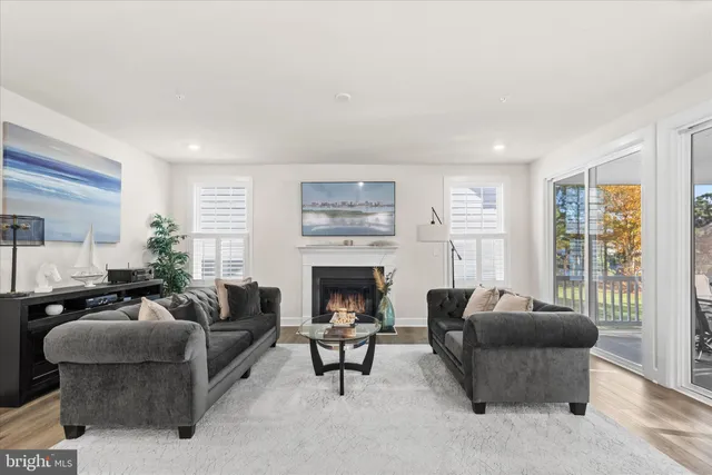 a living room with furniture a fireplace and a large window