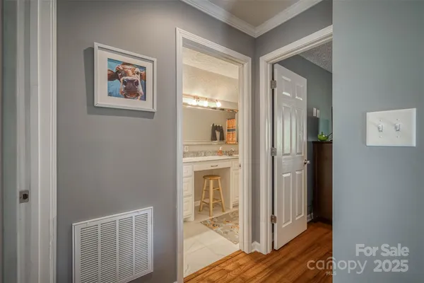 a view of a hallway with wooden floor and a living room