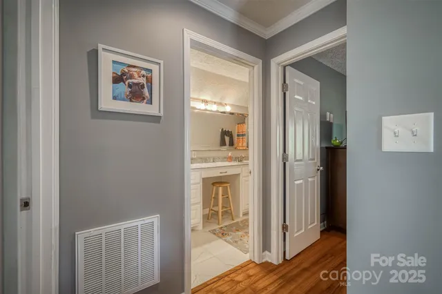 a view of a hallway with wooden floor and a living room