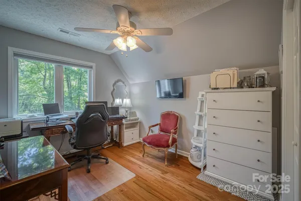 a view of a workspace with furniture and a window