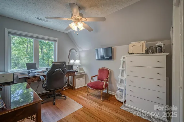 a view of a workspace with furniture and a window