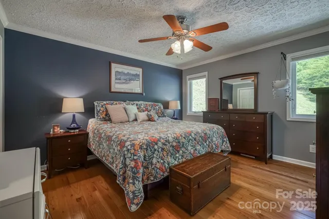 a bedroom with a bed and a dresser with wooden floor