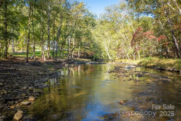a view of a golf ground with large trees