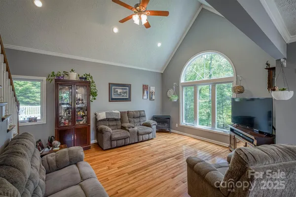 a living room with furniture a large window and a flat screen tv