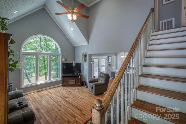 a view of a livingroom with furniture staircase ceiling fan and stairs