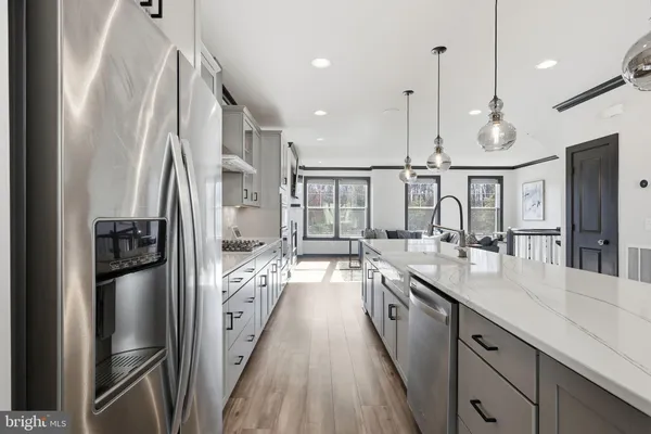 a kitchen with stainless steel appliances granite countertop a refrigerator a oven and a sink