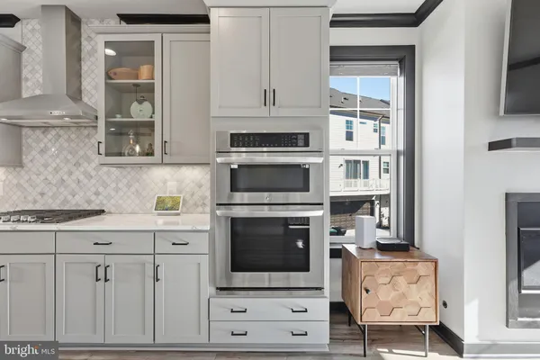 a kitchen with granite countertop a stove oven and white cabinets with wooden floor