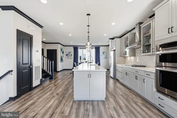 a large kitchen with stainless steel appliances lots of counter space and wooden floor