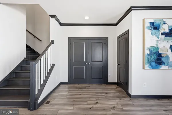 a view of a hallway with wooden floor and staircase
