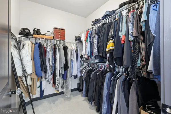 a view of walk in closet with clothes