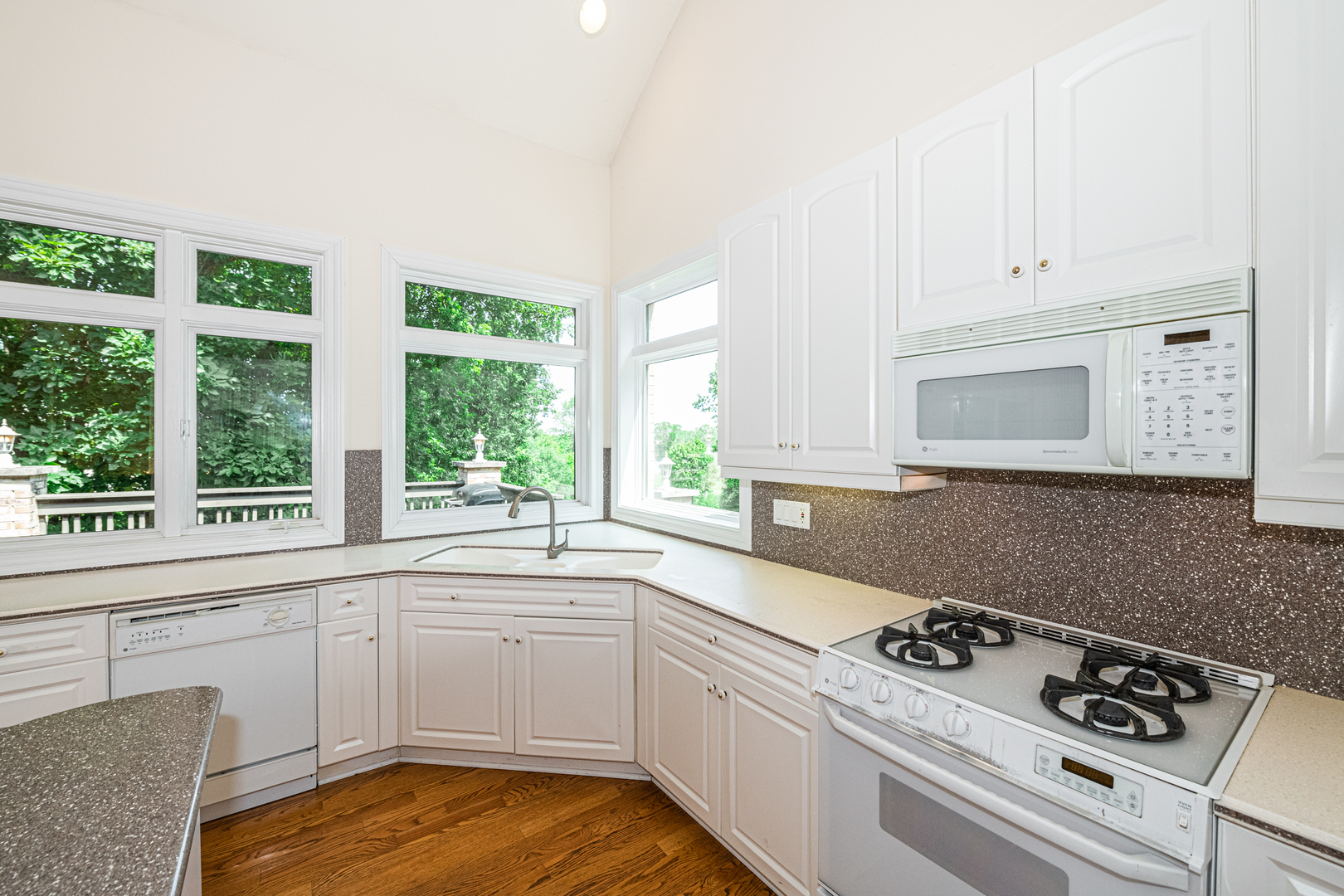 1071 Bonner Road Wauconda, IL 60084 - Photo 17 of 61 a kitchen with a stove a sink and white cabinets with wooden floor
