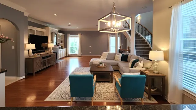 a living room with furniture a flat screen tv and kitchen view