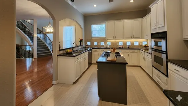 a kitchen with granite countertop a stove a sink and a refrigerator
