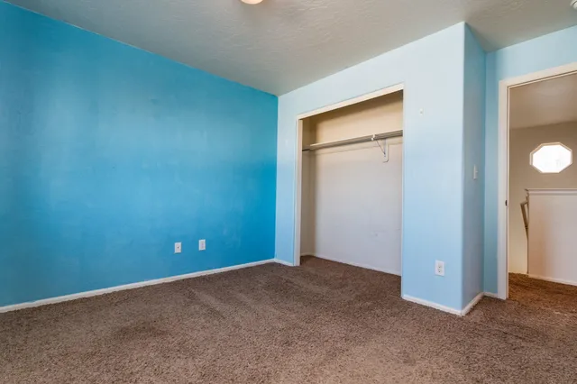 an empty room with closet and mirror