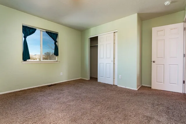 an empty room with windows and closet