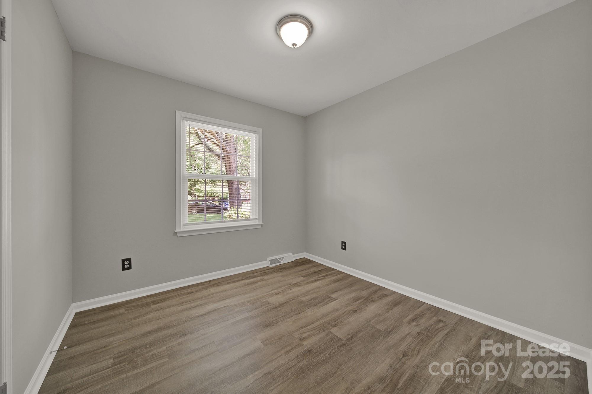 515 Wilcrest Drive Matthews, NC 28105 - Photo 15 of 19 an empty room with wooden floor and windows