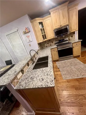 a kitchen with granite countertop stainless steel appliances and wooden cabinets