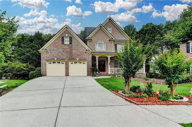 a front view of a house with a yard and potted plants