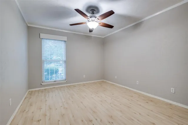 an empty room with wooden floor and ceiling fan