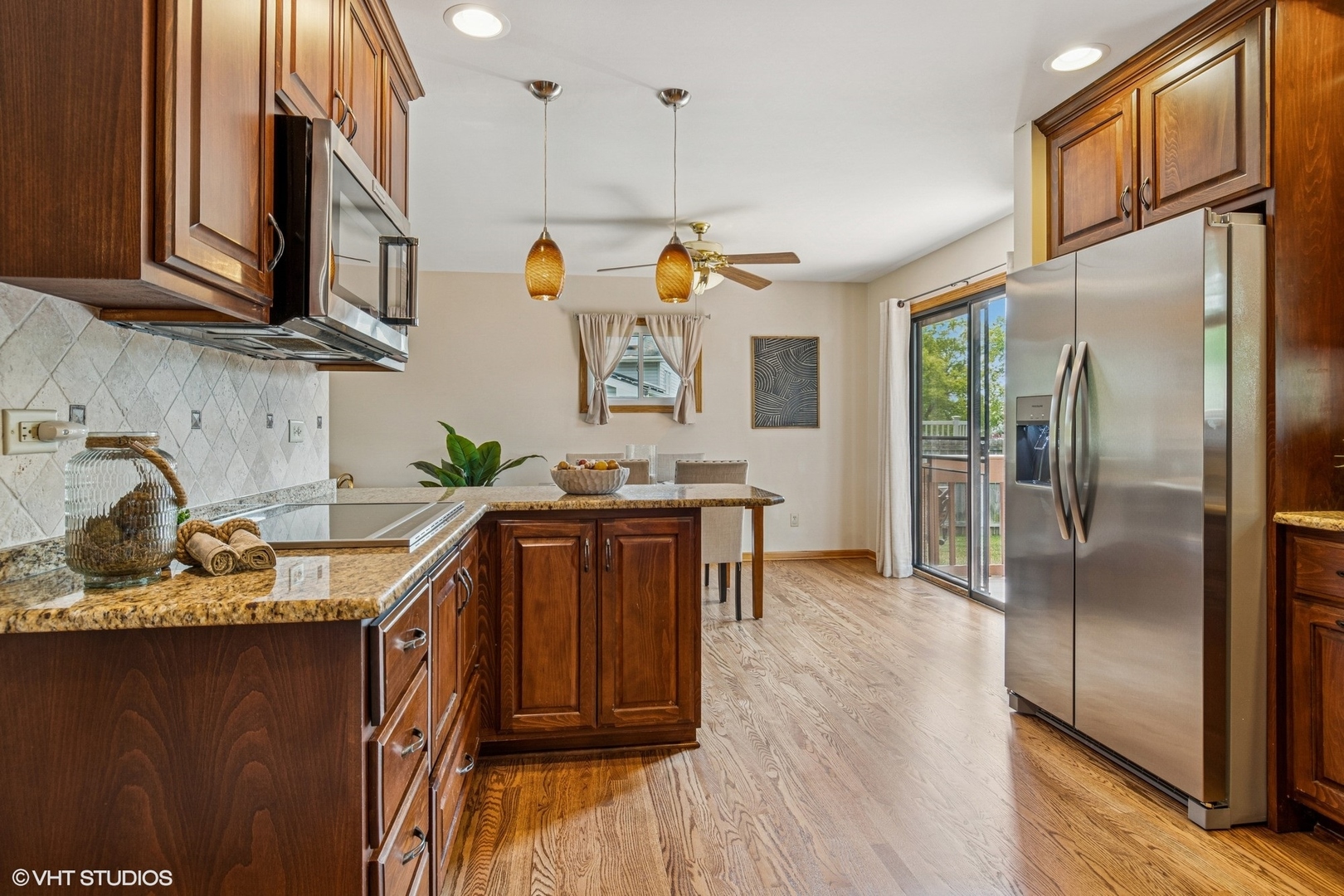 702 Amber Road New Lenox, IL 60451 - Photo 8 of 23 a kitchen with stainless steel appliances granite countertop a refrigerator a sink dishwasher a stove and a dining table with wooden floor