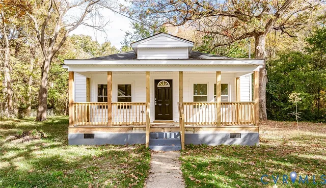 a view of a house with a small yard plants and large tree
