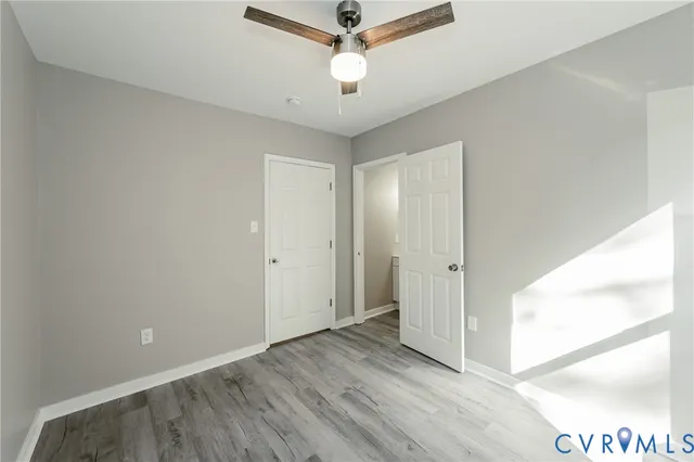 a view of a room with wooden floor and a ceiling fan