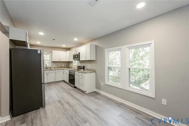 a kitchen with a refrigerator a sink and cabinets