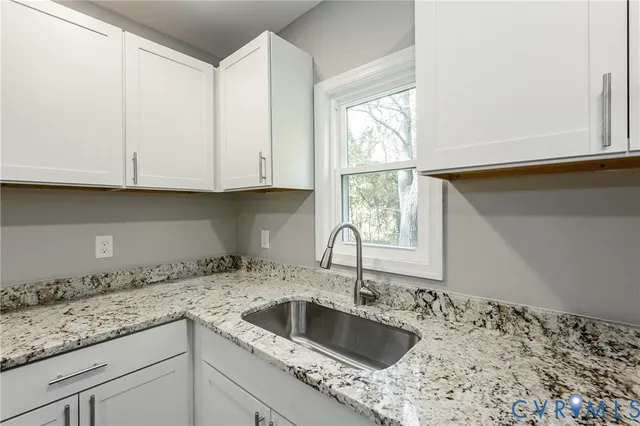 a kitchen with granite countertop a sink and a window