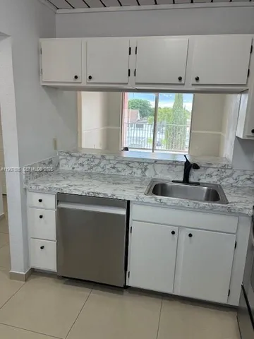 a kitchen with granite countertop a sink and a stove