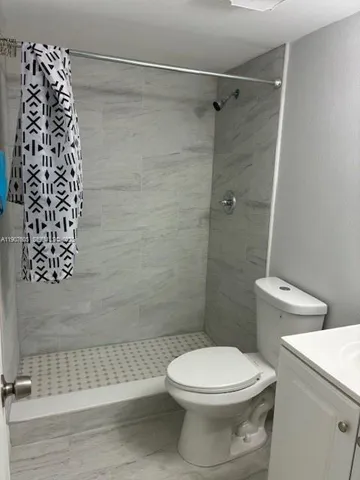 a bathroom with a toilet and a shower