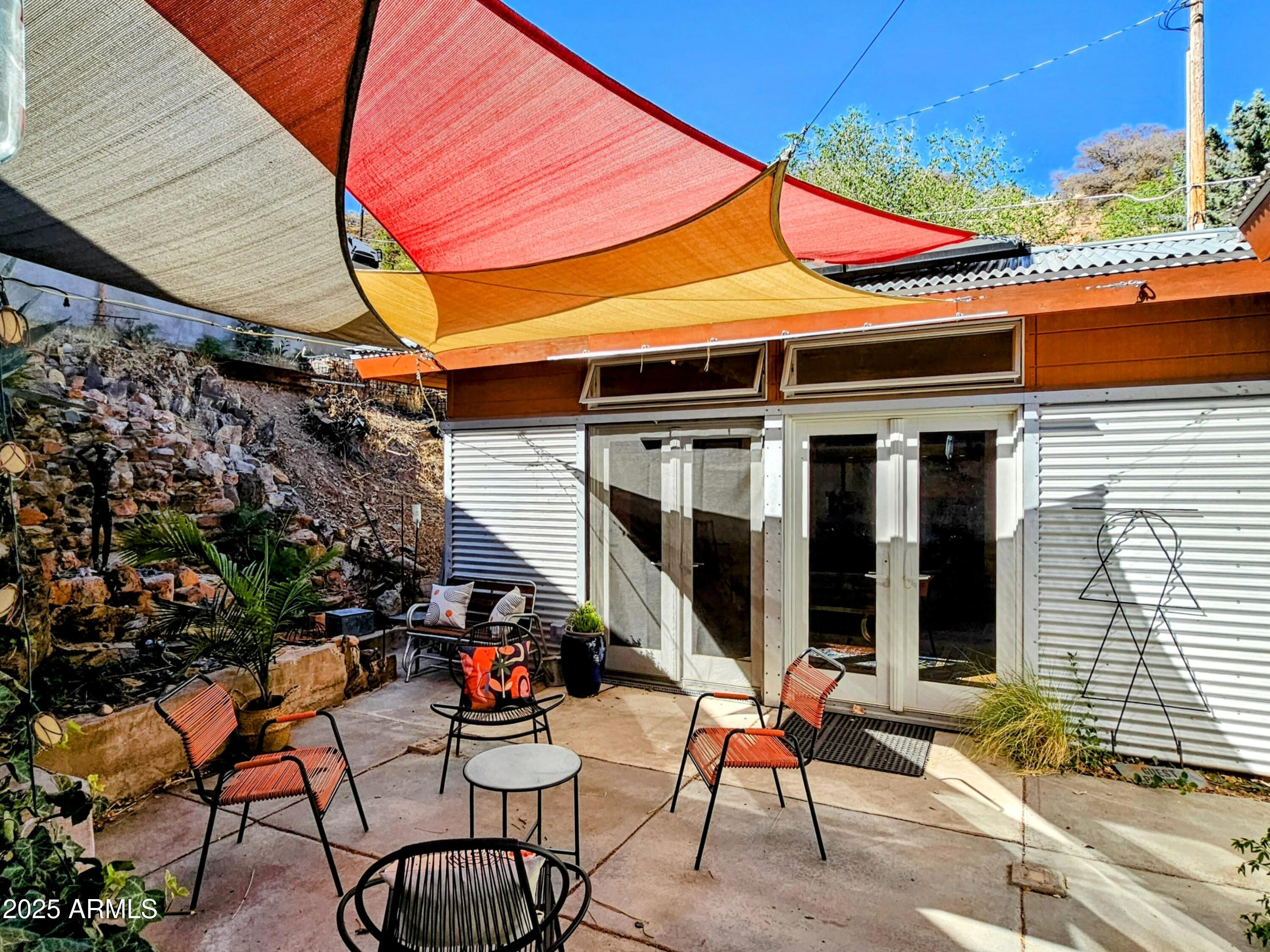 210 Opera Drive Bisbee, AZ 85603 - Photo 23 of 36 a glass top table and chairs in front of house