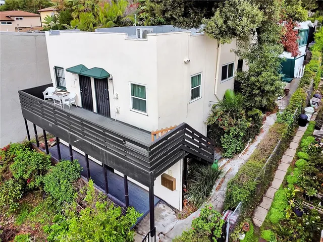 a view of a house with a yard and potted plants