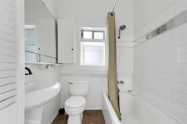 a white kitchen with stainless steel appliances a sink and a large window