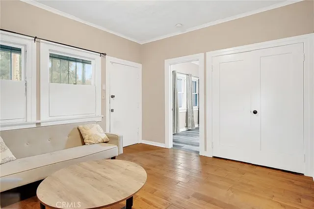 a view of a bedroom with wooden floor and a window