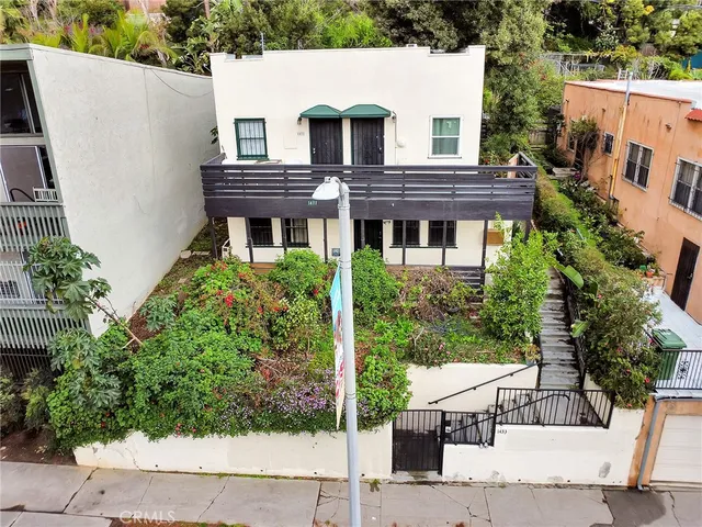 an aerial view of a house with a yard and potted plants