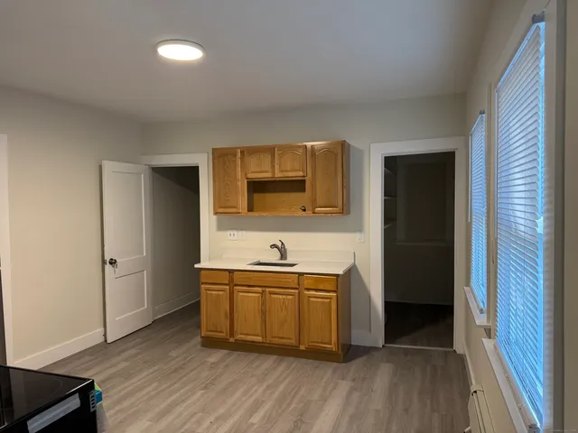 a kitchen with stainless steel appliances granite countertop a sink and wooden floor
