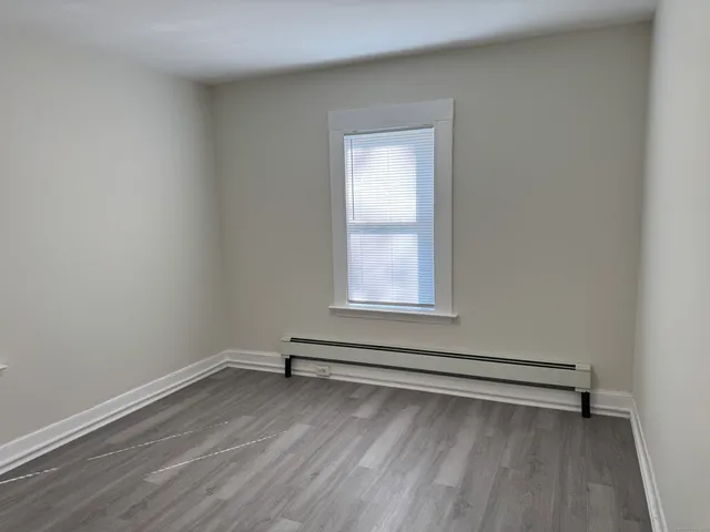 a view of a room with wooden floor and window