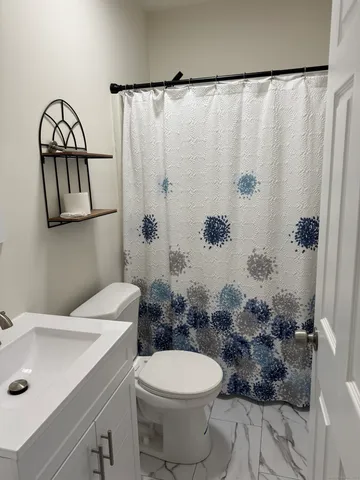 a bathroom with a sink a toilet and shower curtain