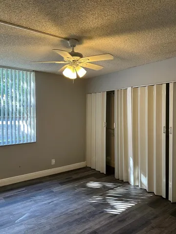 an empty room with wooden floor and window