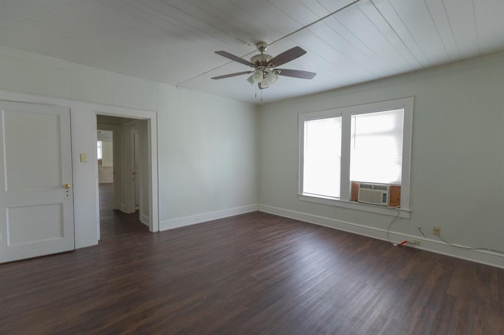 2913 Homan Avenue, Unit 2913 Waco, TX 76707 - Photo 6 of 16 Spacious room featuring dark wood-finish flooring, light-colored walls, and a white paneled ceiling