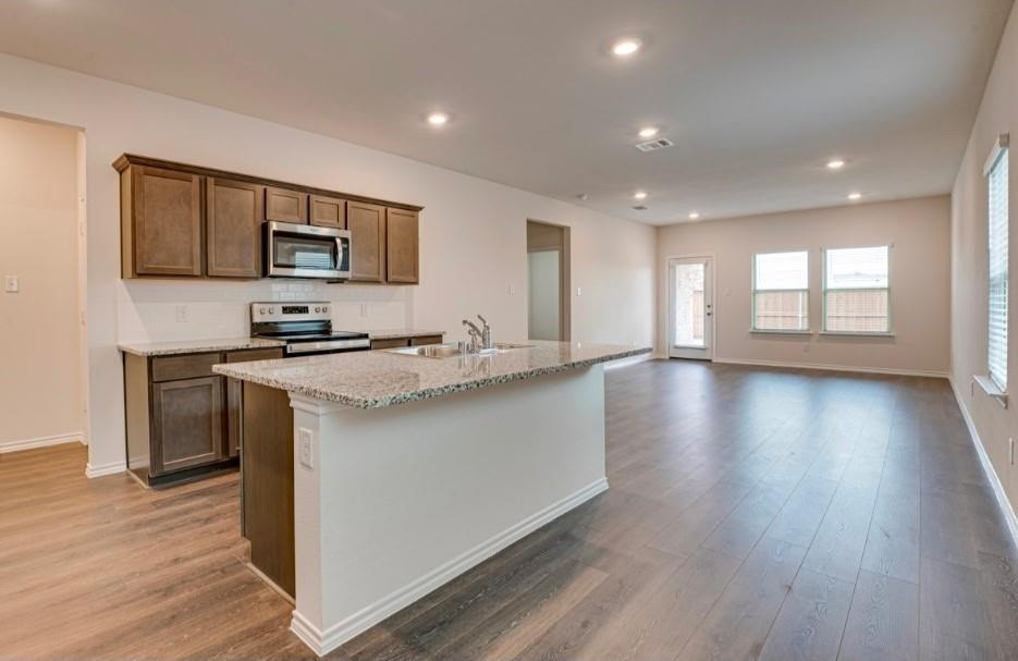 1614 Potomac Lane Blue Ridge, TX 75424 - Photo 2 of 18 Modern kitchen featuring a central island with a granite-style countertop and integrated sink