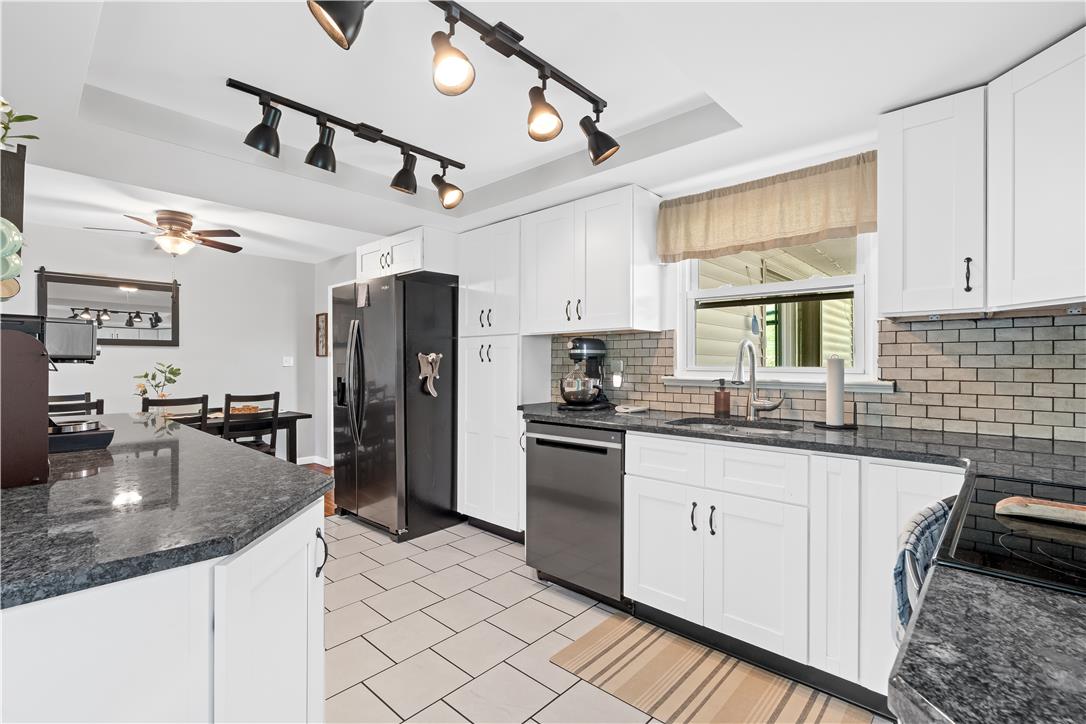 50 Kohls Road Northampton, PA 18067 - Photo 10 of 54 A well-appointed kitchen features dark granite countertops, stainless steel appliances, and sleek white cabinetry.