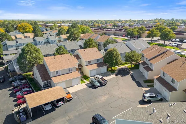 an aerial view of residential houses with outdoor space and parking
