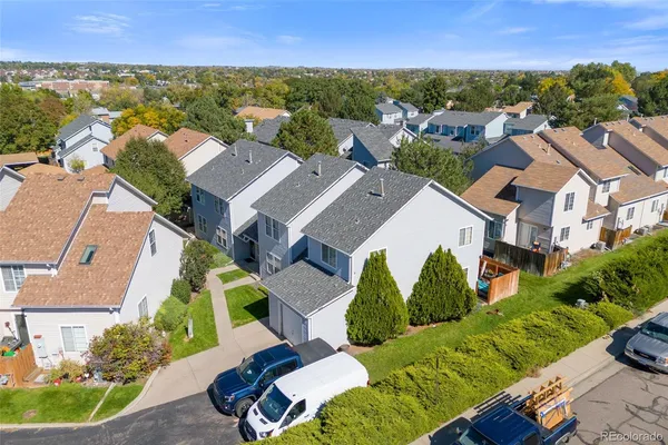 an aerial view of residential houses with outdoor space and trees