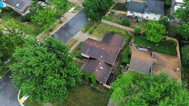an aerial view of a house with garden space and street view