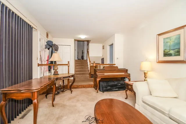 a living room with furniture a rug and a piano
